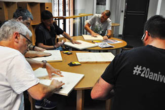 Els participants en el taller treballen en noves obres d'art.